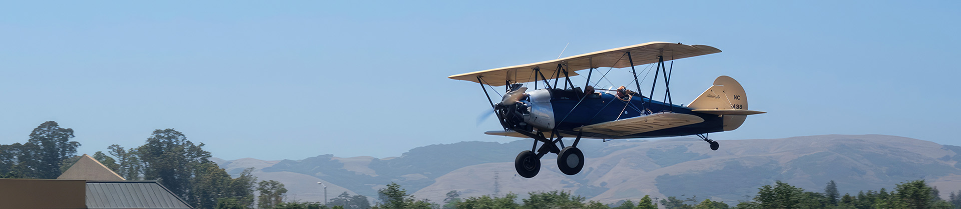 low-flying bi-plane with sonoma hills in background